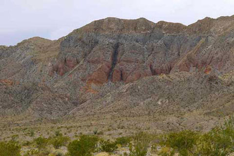 Photo of the red rock wall of the Fish Creek Mountains
